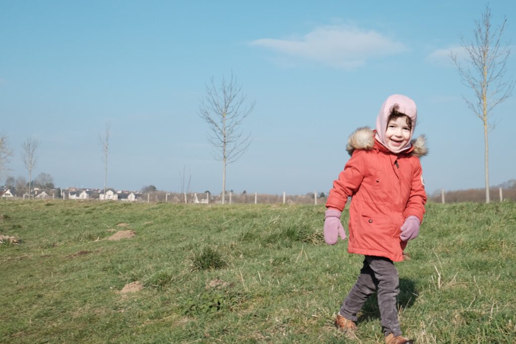 Héloïse habillé chaudement, marche dans l'herbe