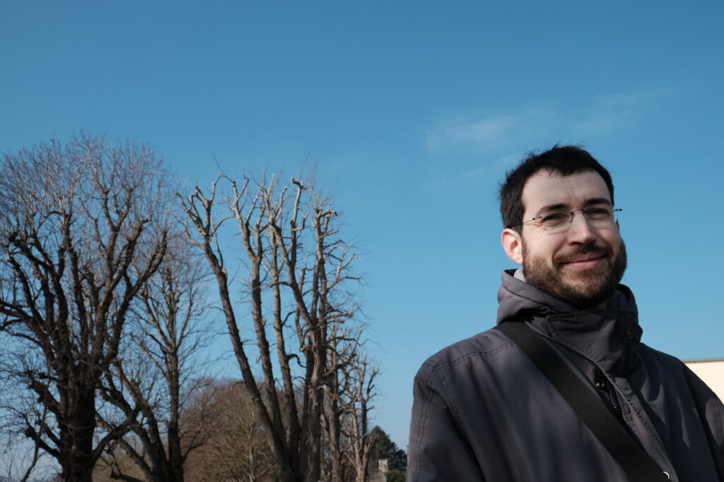 Contre-plongée de Jean-Damien avec sa barbe, sur fond de ciel bleu
