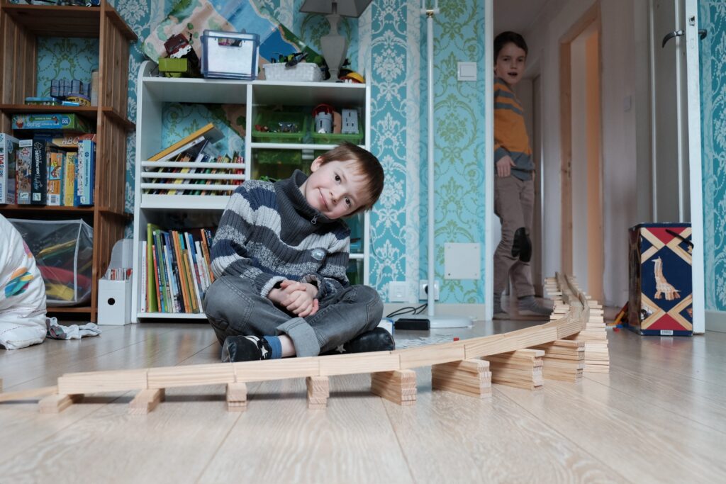 Bilal et Quentin présente leur piste pour les billes, composée des rails du train en bois posés sur des piles de Kapla